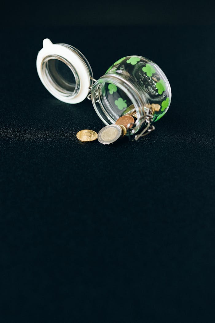 why-choose-us An open jar spilling coins, representing financial concepts on a black backdrop.